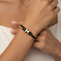 Bracelet Hermès cordon tressé noir porté au poignet